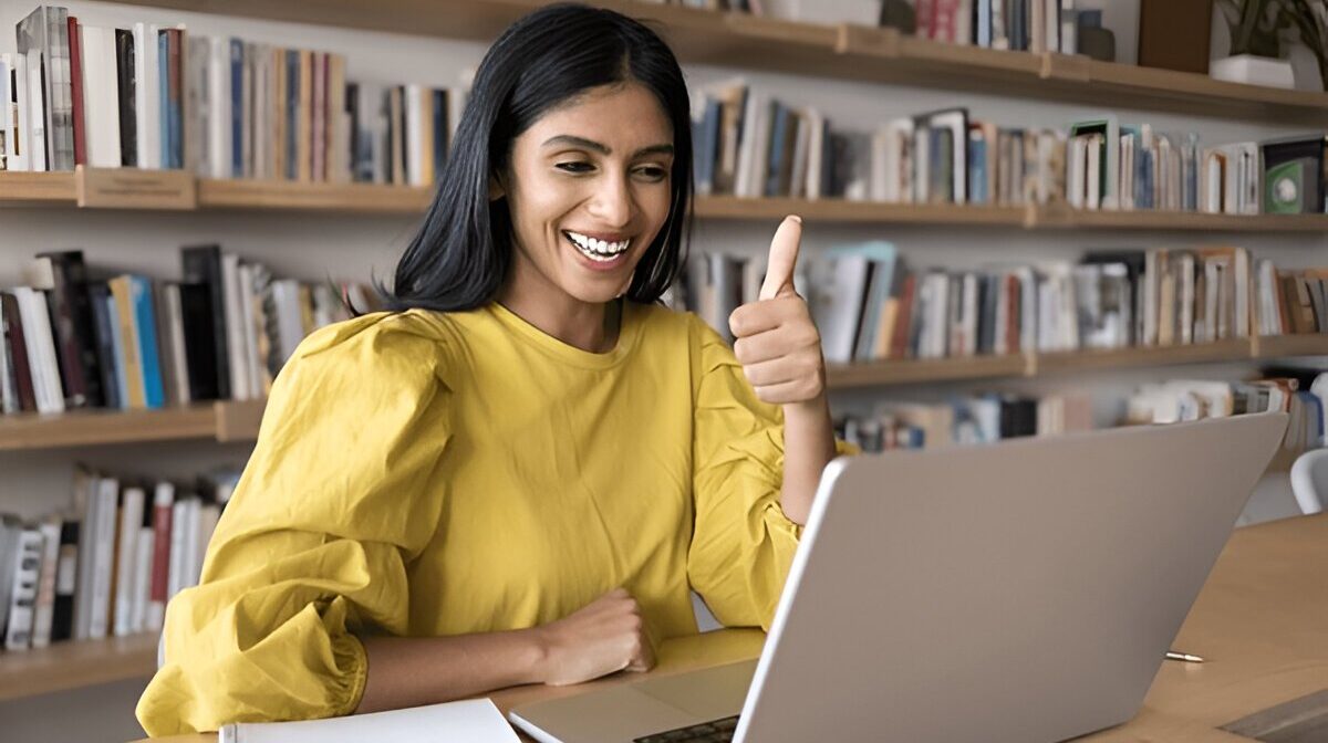 Smiling woman attending distance education course on laptop, showing confidence and academic success